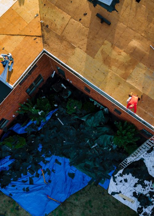 Construction worker on a replacement shingles roof the house installed new shingles of residential building