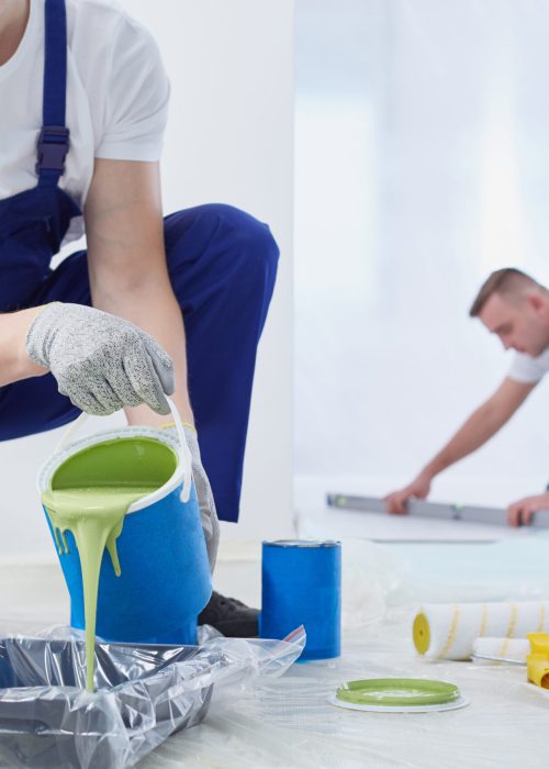 Man painting the walls and spilling the paint